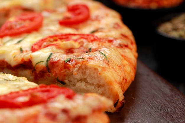 Pizza hecha con queso mozzarella de hojas de albahaca y tomate y masa fina de hojaldre
