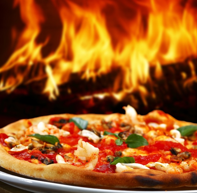 Pizza in einem Holzofen gebacken
