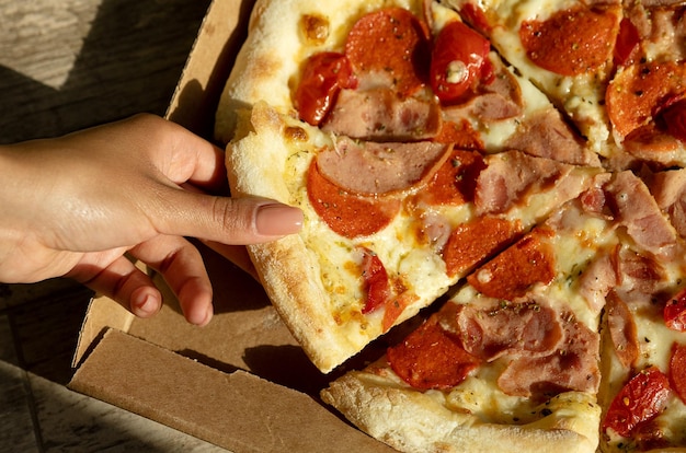 Pizza in einem Karton auf einer dunklen Tafel Draufsicht auf Pizzapaket Pizzalieferung