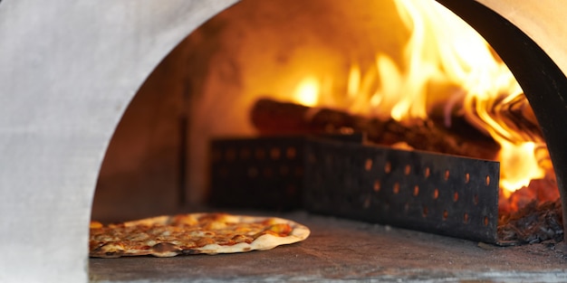 Foto pizza in heißem brennholz ofen für koch