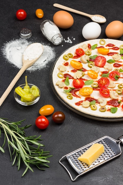 Foto la pizza con ingredientes está lista para hornear.