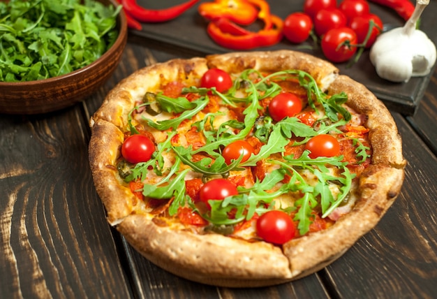 Pizza con ingredientes sobre fondo de madera