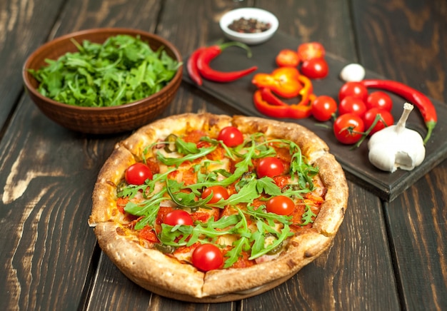 Pizza con ingredientes sobre fondo de madera