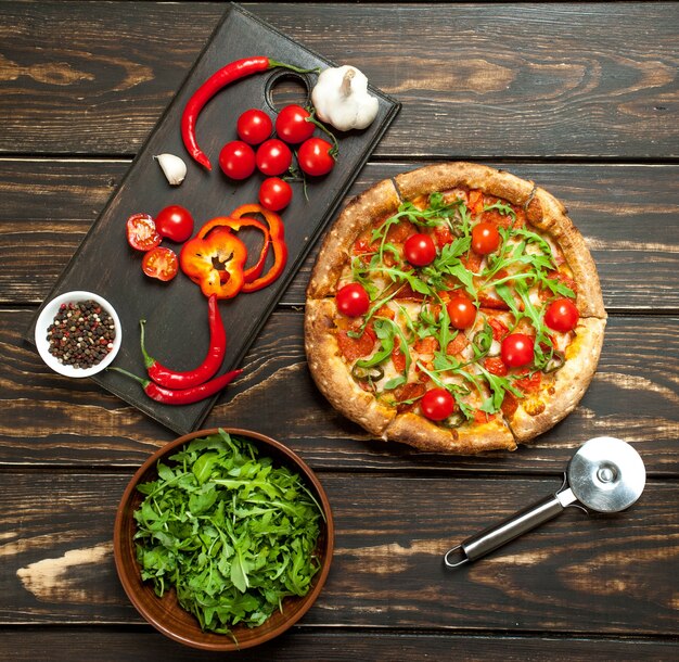 Foto pizza con ingredientes sobre fondo de madera