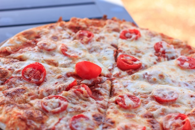 Pizza inteira Margarita com tomates e queijo.