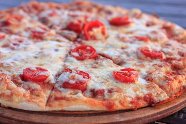 Pizza inteira margarita com tomates e queijo.