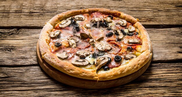 Pizza italiana con aceitunas y tocino.