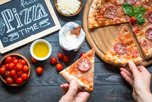 Pizza italiana caliente en una rústica mesa de madera.