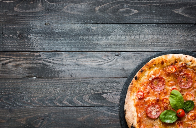 Pizza italiana caliente sobre un fondo de madera rústica