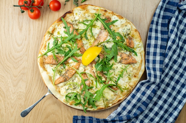 Pizza italiana, caseira com queijo azul de salmonon dor uma mesa de madeira.