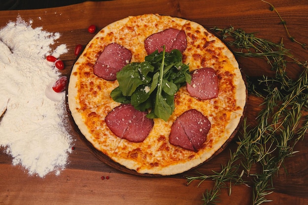 Pizza italiana caseira com queijo mussarela salame molho de tomate pimenta rúcula e especiarias