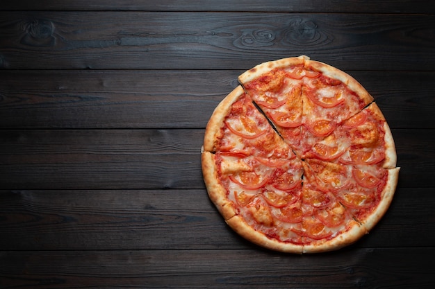 Pizza italiana clásica sobre un fondo oscuro