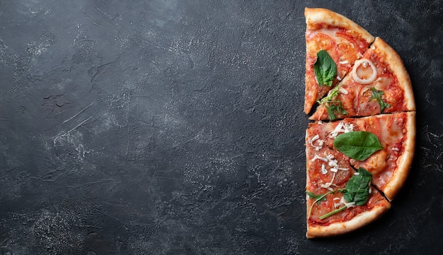 Foto pizza italiana clásica con tomates sobre un fondo oscuro