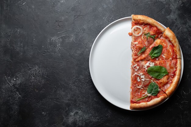 pizza italiana clássica com tomate em um prato branco