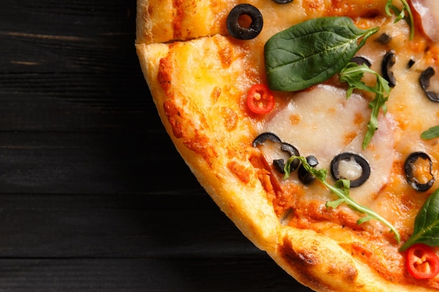 Pizza italiana com azeitonas de queijo espasmódico e ervas em uma vista superior de fundo de madeira escura