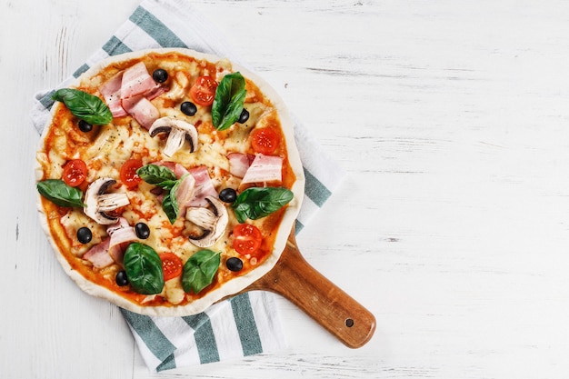 Pizza italiana com cogumelos, manjericão, tomate, azeitonas e queijo