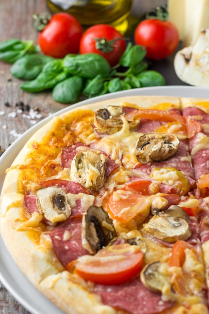 Pizza italiana com ingredientes em um fundo de madeira, close-up