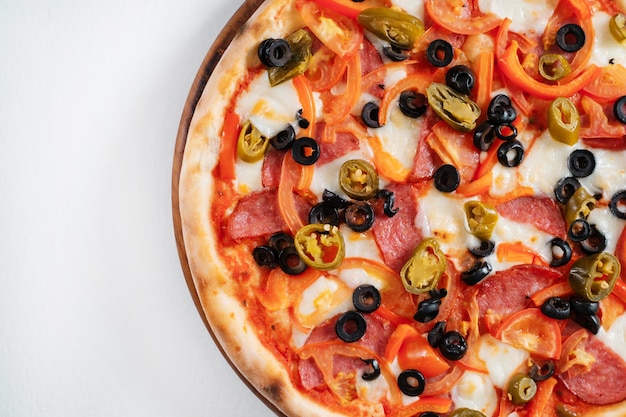 Pizza italiana com presunto, azeitonas, pimentas e ervas, vista superior