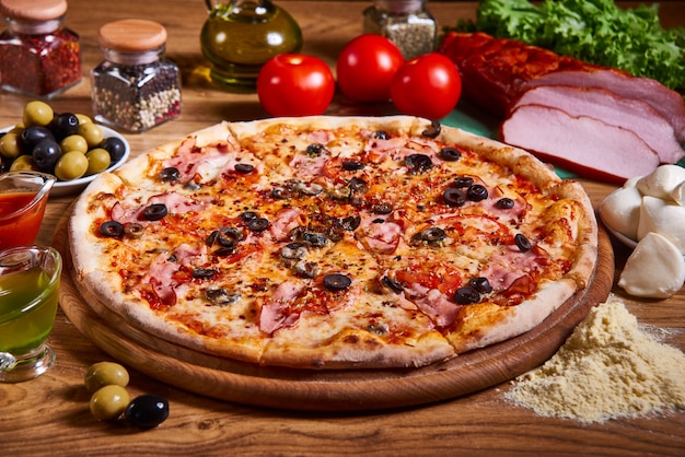 Pizza italiana deliciosa servida na mesa de madeira. pizza em fatias. composição de pizza saborosa