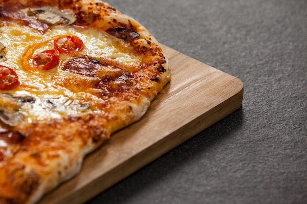 Pizza italiana deliciosa servida na placa de madeira