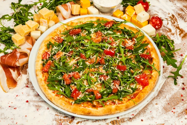 Pizza italiana con diferentes tipos de queso, verduras y carne.