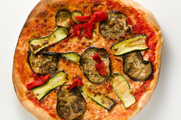 Pizza italiana grande con verduras asadas aislado en mesa blanca