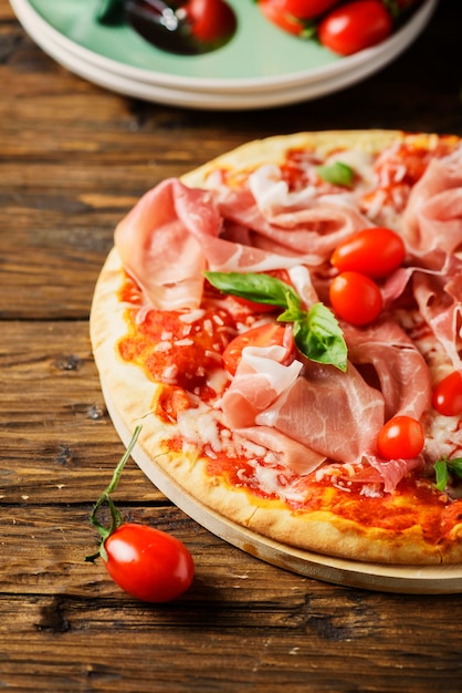 Pizza italiana con mozzarella, tomate y tocino.
