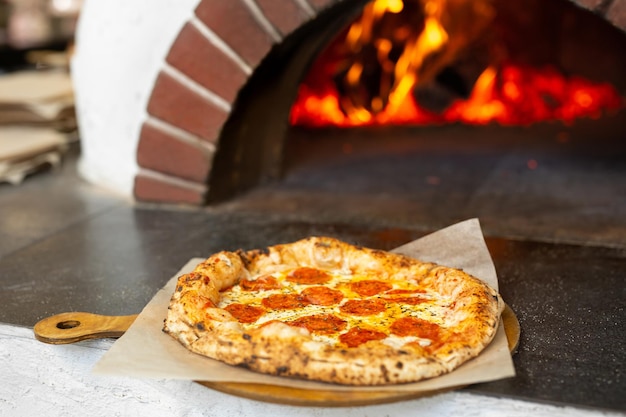 La pizza italiana preparada en un plato de madera está lista para ser servida en el restaurante