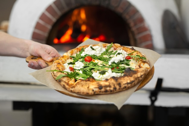 Pizza italiana pronta em uma placa de madeira está pronta para ser servida no restaurante