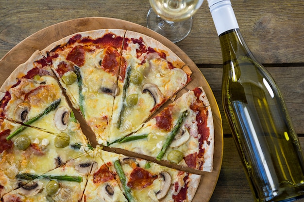 Pizza italiana, servida em uma bandeja de pizza com uma garrafa de vinho