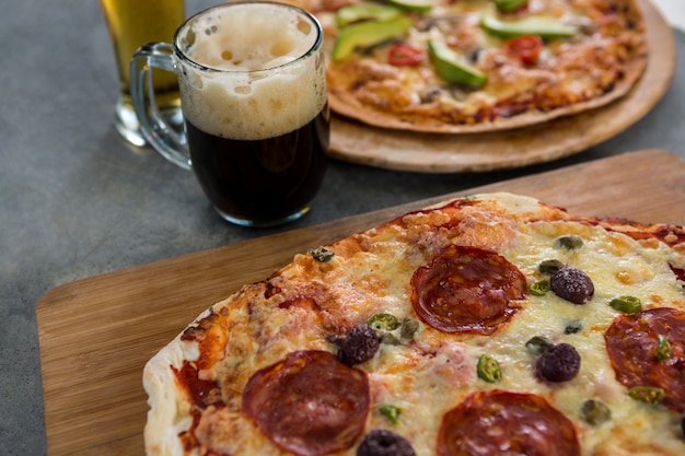 Pizza italiana servida con una jarra de cerveza