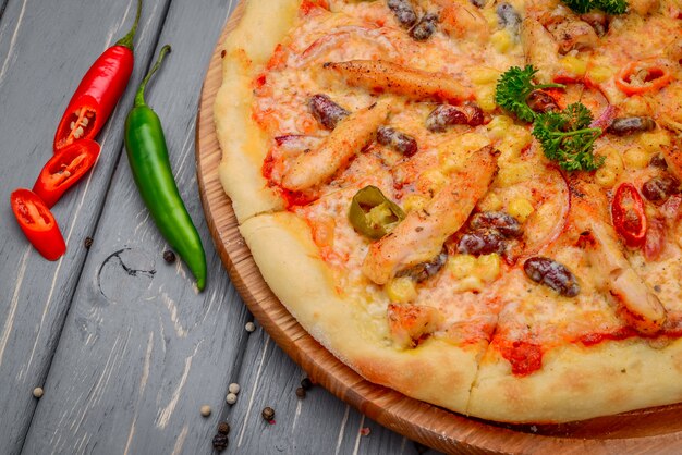 Pizza italiana tradicional com frango e feijão na mesa de madeira