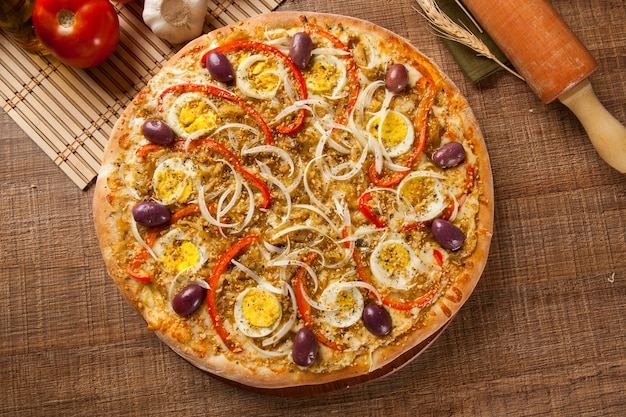 Pizza italiana tradicional com ingredientes na madeira.