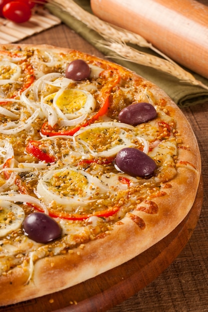 Pizza italiana tradicional com ingredientes na madeira.