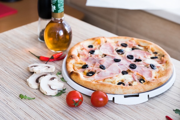 Pizza italiana tradicional com presunto e azeitonas