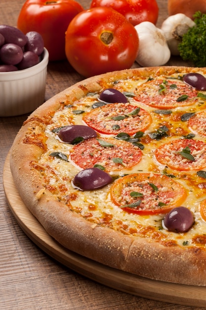 Pizza italiana tradicional con ingredientes en madera.