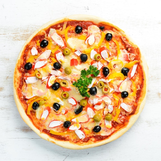 Pizza italiana tradicional con palitos de cangrejo y aceitunas Vista superior espacio libre para el texto Estilo rústico