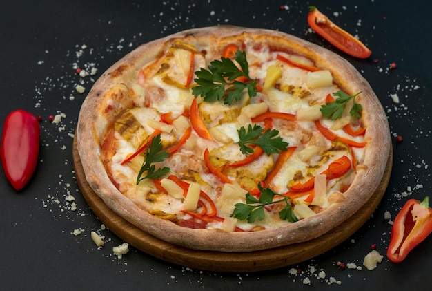 Pizza italiana tradicional con queso de jamón y tomates en un fondo oscuro