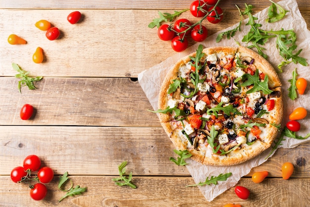 Pizza italiana de verduras con tomates sobre fondo wodeen, espacio de copia, vista superior