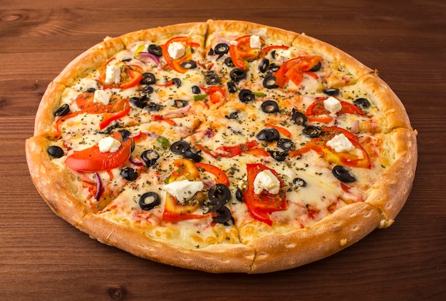 Pizza de jamón con queso, tomate y pimiento.