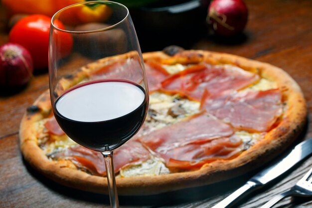 Pizza con jamón y vino tinto