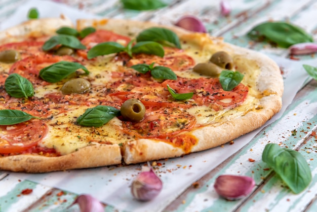 Pizza de leña recién hecha vista desde arriba en tableros turquesa rústicos