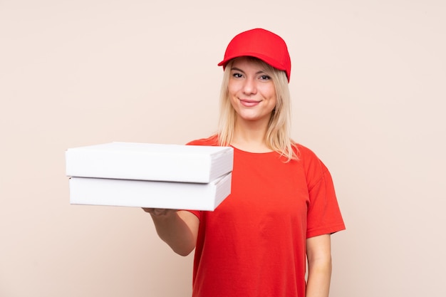 Pizza Lieferung russische Frau, die eine Pizza über isolierter Wand mit glücklichem Ausdruck hält