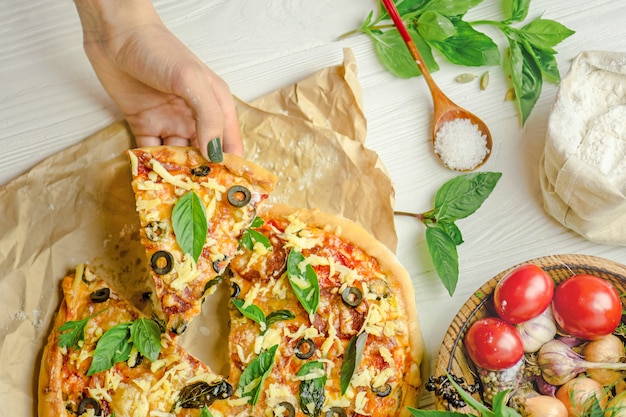 Pizza y mano de cerca sobre fondo blanco