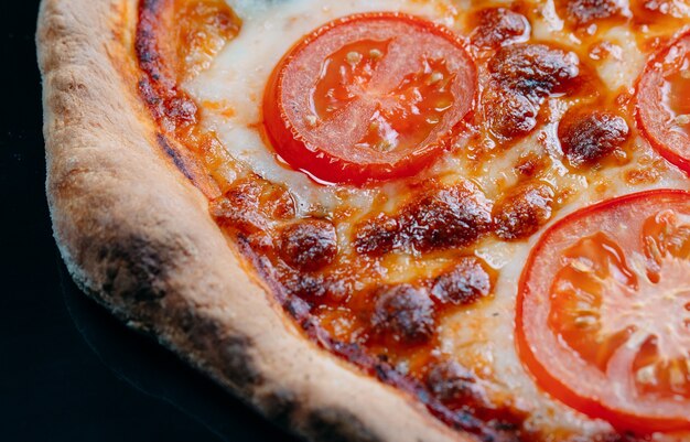 Pizza Margarita de cerca con queso y tomates.