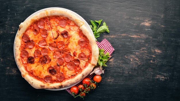 Pizza Margarita con salchichas y salsa de tomate Sobre un fondo de madera Vista superior Espacio libre para el texto