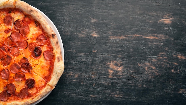 Pizza Margarita con salchichas y salsa de tomate Sobre un fondo de madera Vista superior Espacio libre para el texto