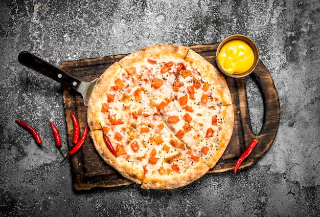 Pizza margarita con salsa y cerveza fresca.