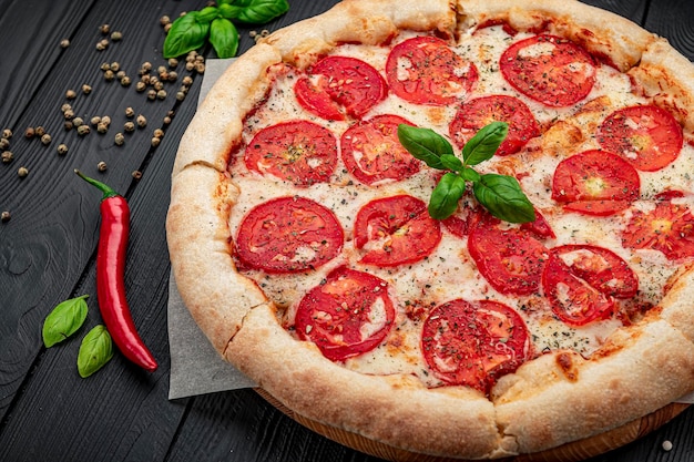 Pizza Margherita em fundo preto, vista superior Pizza Margarita com tomate, manjericão e queijo mussarela