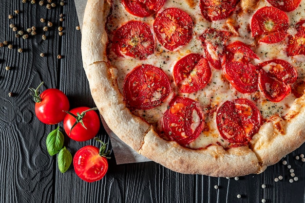 Pizza Margherita em fundo preto, vista superior Pizza Margarita com tomate, manjericão e queijo mussarela